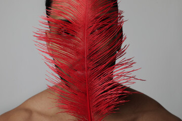 American Indian warrior. Man with red feather. Fine-art photo. Isolated.