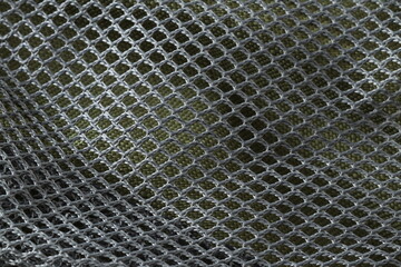 The black texture of the mesh fabric of the backpack. 