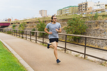 White man with long hair running in park and smiling. Sport Concept