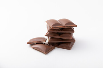 Cubes of delicious milk chocolate isolated on white background.