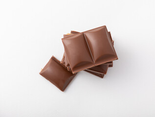 Cubes of delicious milk chocolate isolated on white background.