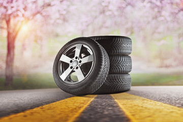 Car tires with a great profile in the car repair shop.  Set of summer or winter tyres in front of...