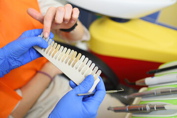 the dentist selects the right shade of teeth on special equipment.