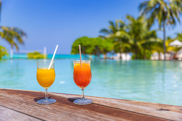 Colorful cocktails served on luxury tropical resort hotel in Maldives. Poolside with blurred palm...