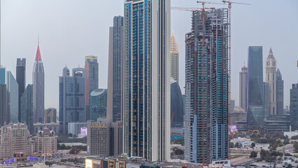 Fototapeta na wymiar Row of the tall buildings around Sheikh Zayed Road and DIFC district aerial day to night timelapse in Dubai