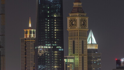 Obraz premium Tall buildings around Sheikh Zayed Road and DIFC district aerial night timelapse in Dubai