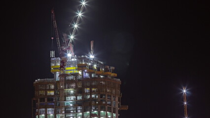 The construction process of a residential complex aerial night timelapse.