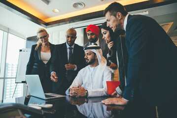 Cinematic image of a multiethnic business team working together in Dubai in offices. Concept about finance, investments and real estate market