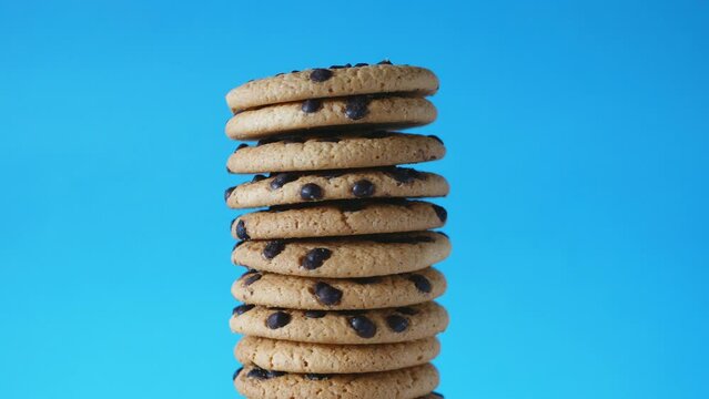 A stack chocolate chip cookies rotate on a blue background. American cookies close up.