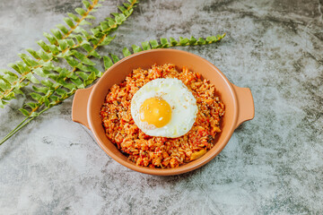 Korean food kimchi fried rice dish with fried egg on white plate