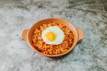 Korean food kimchi fried rice dish with fried egg on white plate