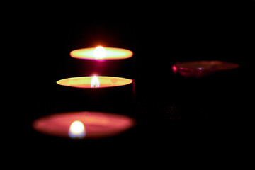 Candles in the dark with soft selective focus and bokeh.Burning candles on the table in honor of the commemoration in the dark.