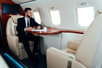 Businessman flying on his private jet. Successful business man and entrepreneur flying to his meeting. Famous salesman and speaker going to a sales event