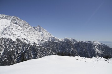 Winter landscape, mountain ridge in snow in a sunny weather with bright blue sky. View from Triund mountain.