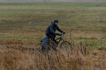 Russian bicyclist in the autumn field, Moscow Region