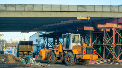 Motor grader on road construction. Orange bulldozer on bridge road construction site. Detour. Road Closed.