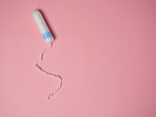 female tampon on a pink background. Hygienic white tampon for women. Cotton swab. Menstruation, Tampons on a pink background.