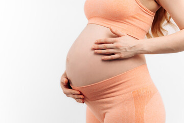 pregnant woman touching her belly on a white background. Woman expecting a baby, happy pregnant woman with big belly