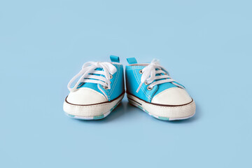 Baby's little shoes on a colorful background. The concept of waiting for a baby and the concept of traveling with baby, children's lifestyle. Copy space, flat lay