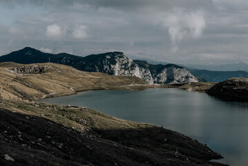 Fototapeta na wymiar See im Gebirge mit Ausblick im Hintergrund
