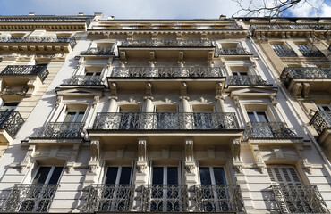 Fototapeta premium The facade of traditional French house with typical balconies and windows. Paris.