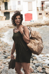 Beautiful female Latina carrying a bag in the shore