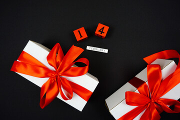 white gifts with red bows on February 12 are on a black background
