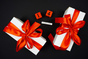 white gifts with red bows on February 12 are on a black background