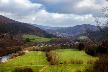 Fototapeta na wymiar Fernblick in Tal mit Fluss und grünen Wiesen