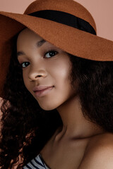 Close up portrait of sensual young female in hat. Clean skin. Healthy care. Portrait of beautiful african american in hat isolated. Studio shoot. Portrait of beauty model with natural nude make up