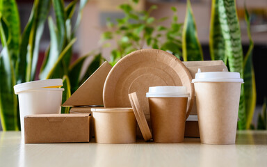Paper eco-friendly disposable tableware on the background of green plants. The concept of caring for the environment.