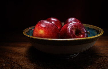 4 red apples in clay bowl