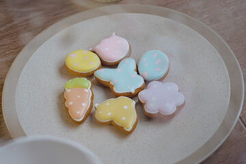 Gingerbread Cookies in shape of eggs and Easter bunny. Easter background with spring flowers.
