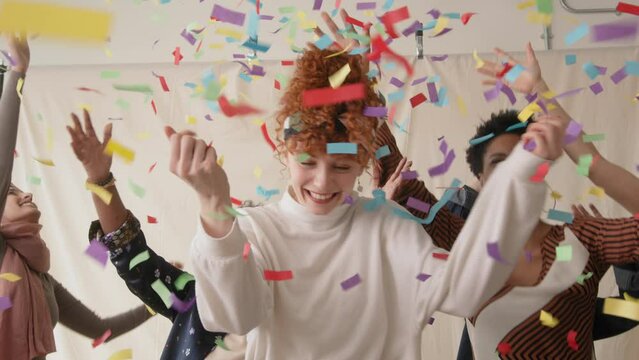 Slow motion of cheerful multi ethnic women celebrating and dancing with ticker tape falling