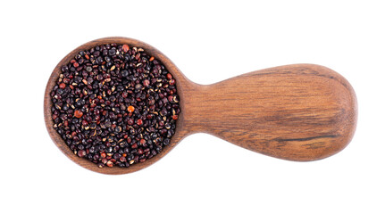 Black quinoa seeds in wooden spoon, isolated on white background. Pile of raw kinwa. Top view.