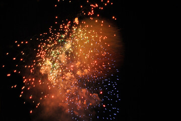 Colorful salute, great explodes in different colors in the night sky, beautifully dissolving in the air.