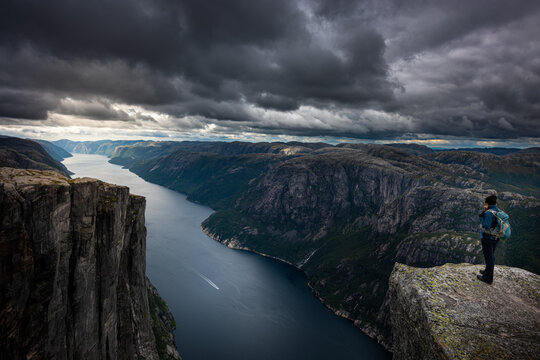 Eagle head viewpoint near Kjeragbolten Lysebotn Norway Woman stands by the edge of lysefjord