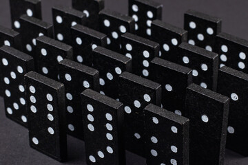Black Dominoes on dark background, Closeup scattered dominoes on a gray, table. Board game, Game night Dominos table game