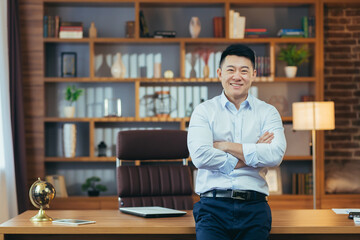 Portrait of a successful businessman working in a classic office, Asian smiling and happy looking...