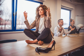 A group of businessmen meditate in the office. - obrazy, fototapety, plakaty