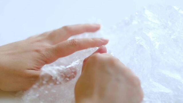 ASMR, woman presses plastic bubble wrap as a stress relief. Popping bubble wrap