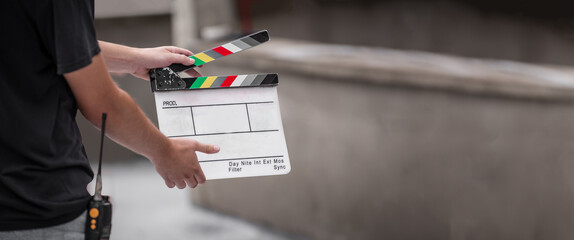 Man holding a clapperboard in front of the camera