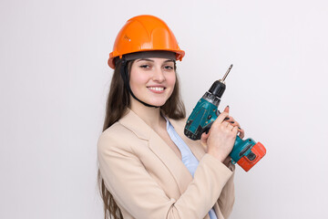 Girl engineer in an orange construction helmet with a screwdriver and a hammer on a white background.