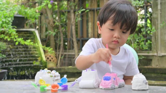 DIY Plaster Model Painting with colorful paints,Little child painting the plaster model,Creative concept. Water colors.