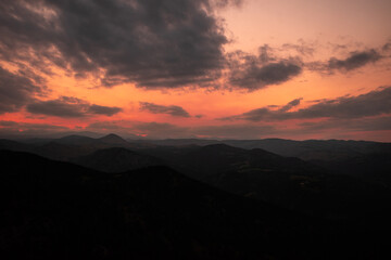 Fototapeta premium Beautiful colorful yellow and orange sunset with clouds over dark mountains in the Rocky Mountains in Colorado, USA.