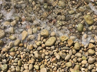 Top view of round river stones floor with water at top