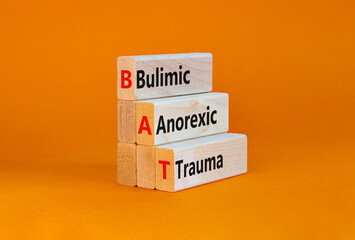 Naklejka premium BAT bulimic anorexic trauma symbol. Concept words BAT bulimic anorexic trauma on blocks on a beautiful orange table, orange background. Medical and BAT bulimic anorexic trauma concept. Copy space.