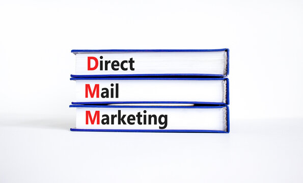 DMM direct mail marketing symbol. Concept words DMM direct mail marketing on books on a beautiful white table, white background. Business and DMM direct mail marketing concept. Copy space.