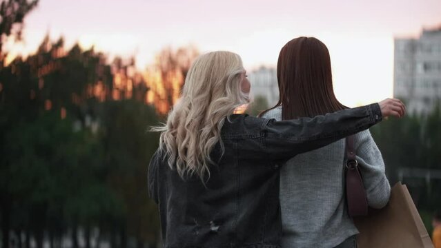 Hugging happy friends. Positive moment. Carefree lifestyle. Joyful women besties embracing together walking outdoors at city street.
