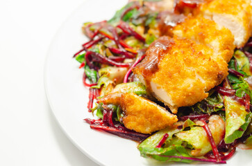 Breaded crispy chicken breast fillet with mixed salad and grated beetroot